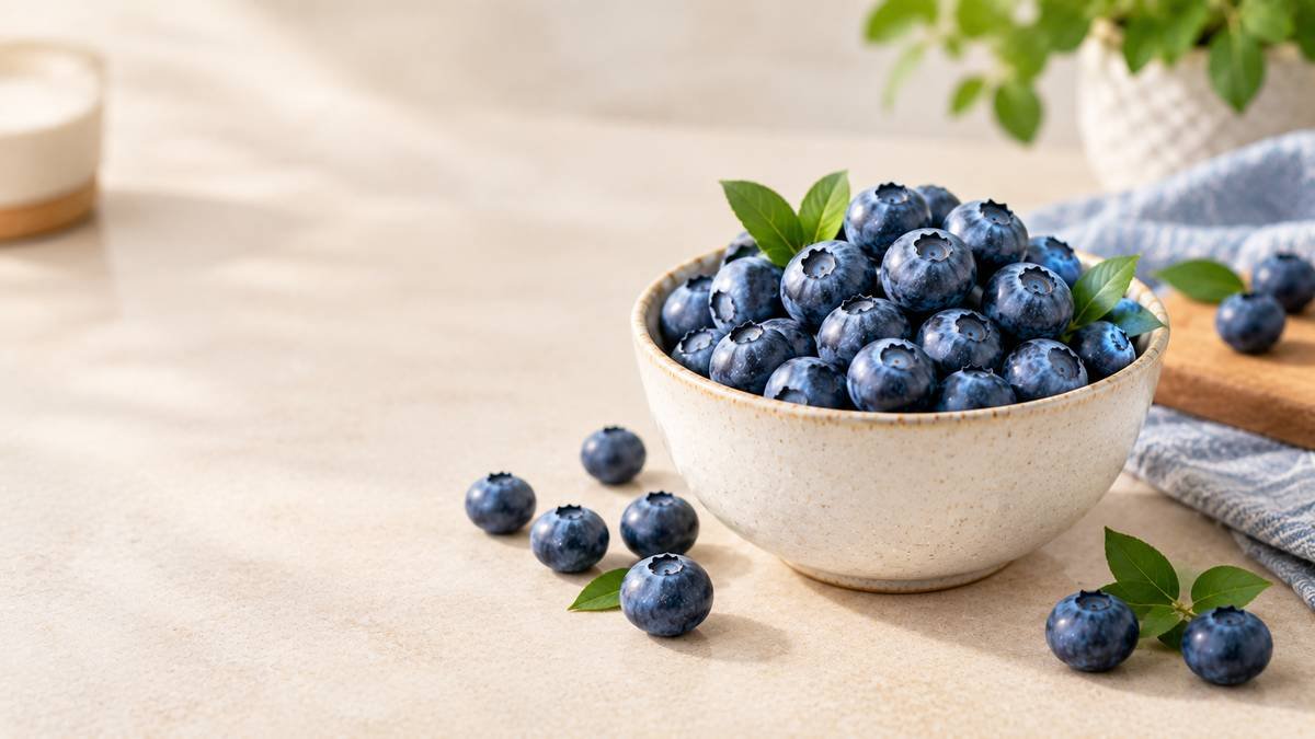 Fresh blueberries in a ceramic bowl on a neutral tabletop