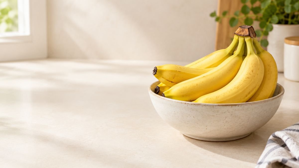 Fresh ripe bananas arranged on a neutral kitchen surface