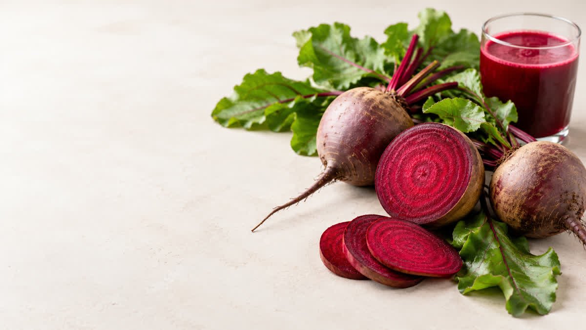 Fresh whole and sliced beetroot with green leaves, highlighting beetroot as a nutritious food with potential health benefits.