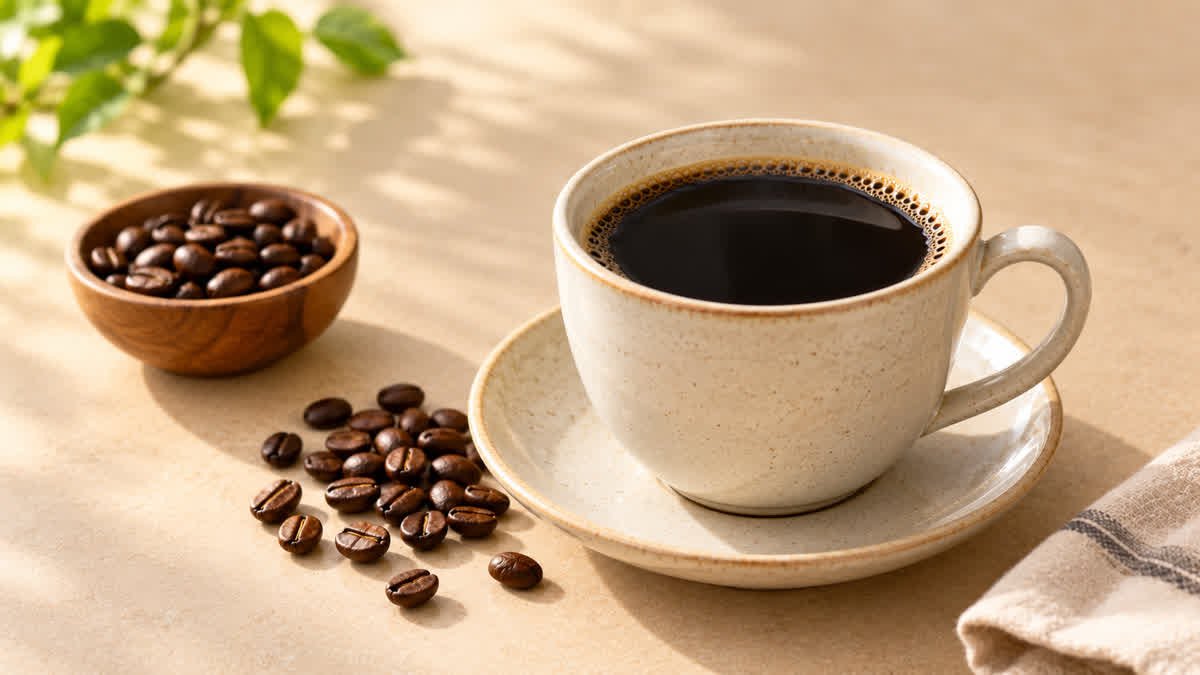 Cup of plain black coffee beside coffee beans illustrating the discussion of coffee and weight loss.