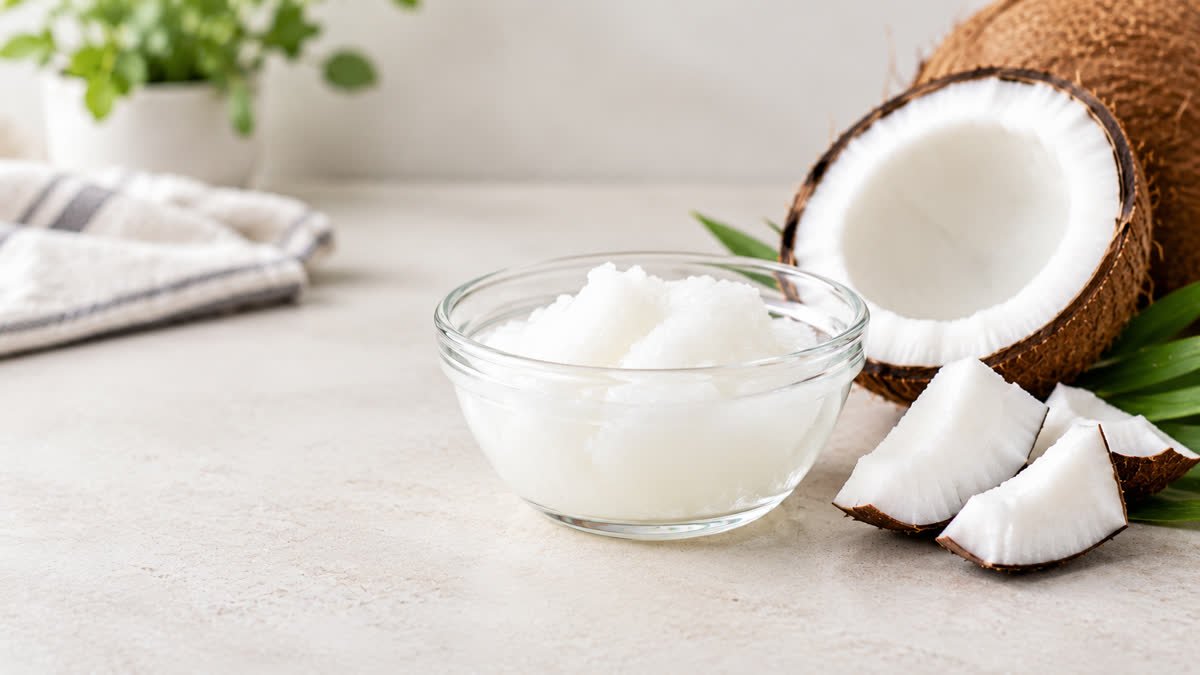 Bowl of coconut oil beside fresh coconut pieces for an article about coconut oil and blood sugar control.