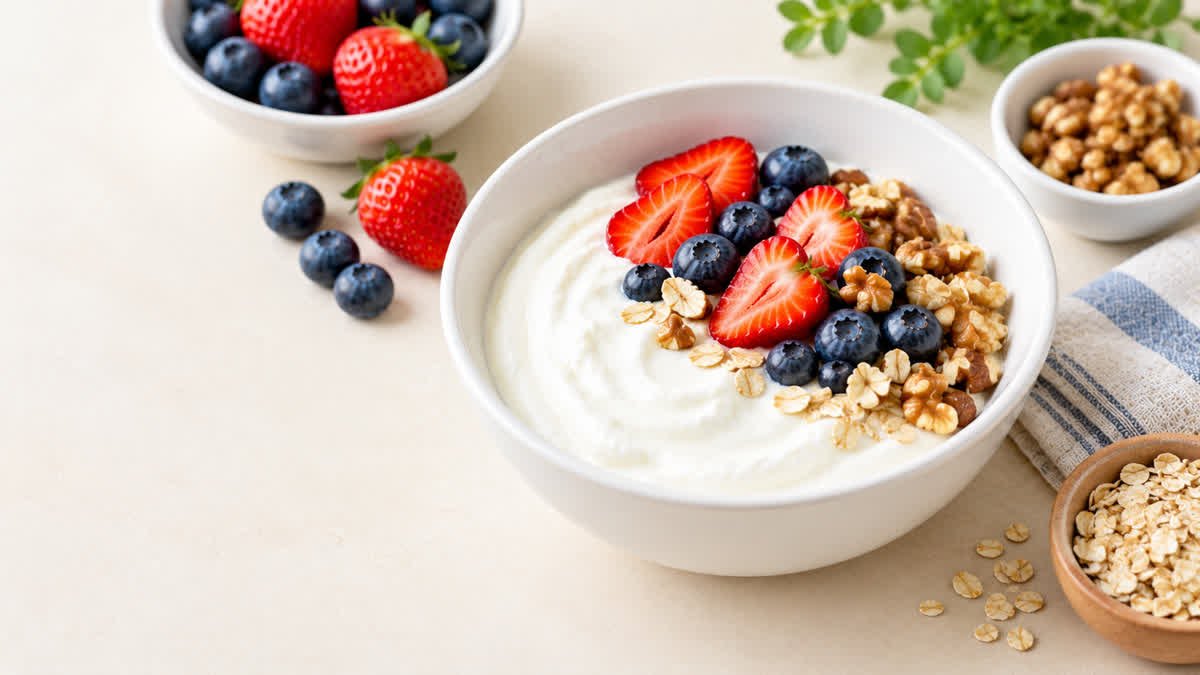 Bowl of plain Greek yogurt with blueberries, strawberries, walnuts, and oats