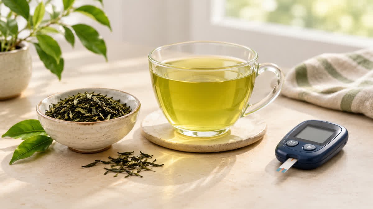 Cup of green tea with tea leaves and a blood glucose meter on a neutral surface.
