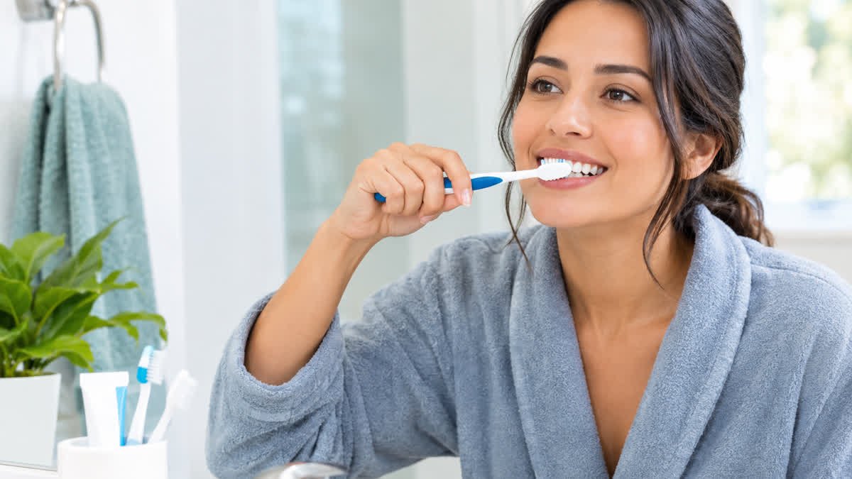 Woman brushing her teeth during her morning oral hygiene routine.