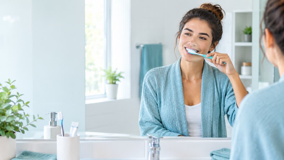 Adult brushing their teeth as part of a daily oral hygiene routine.