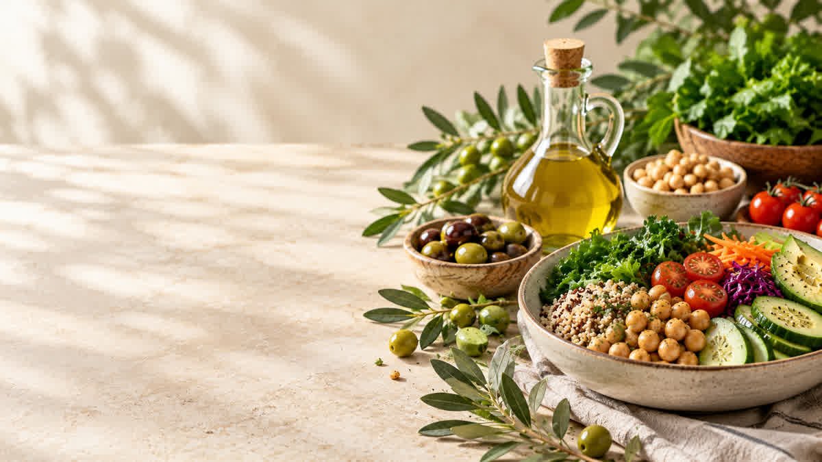 Extra virgin olive oil with fresh olives and vegetables as part of a heart-healthy meal