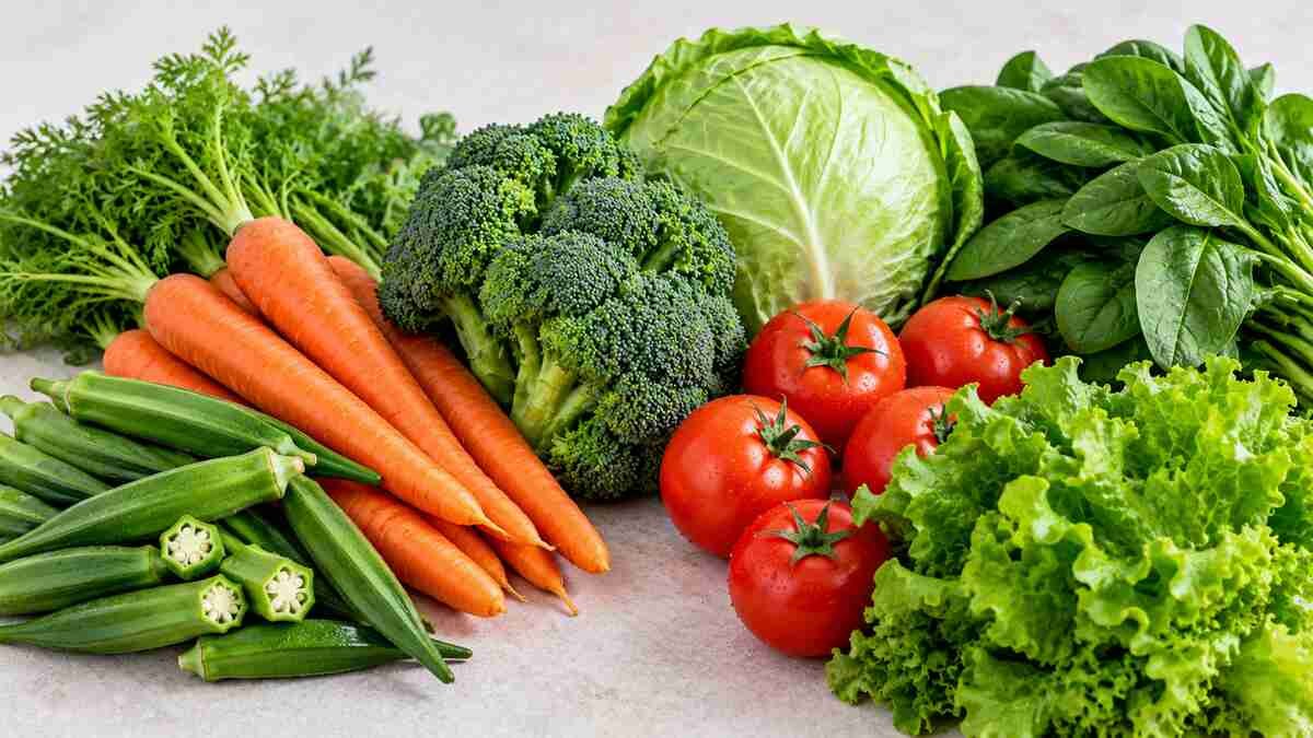 Assorted fresh vegetables including okra, carrots, broccoli, cabbage, and spinach